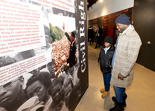 Father and son look at exhibit at America's Black Holocaust Museum