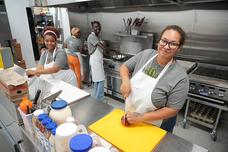 Employees work in the kitchen at Kinship Café